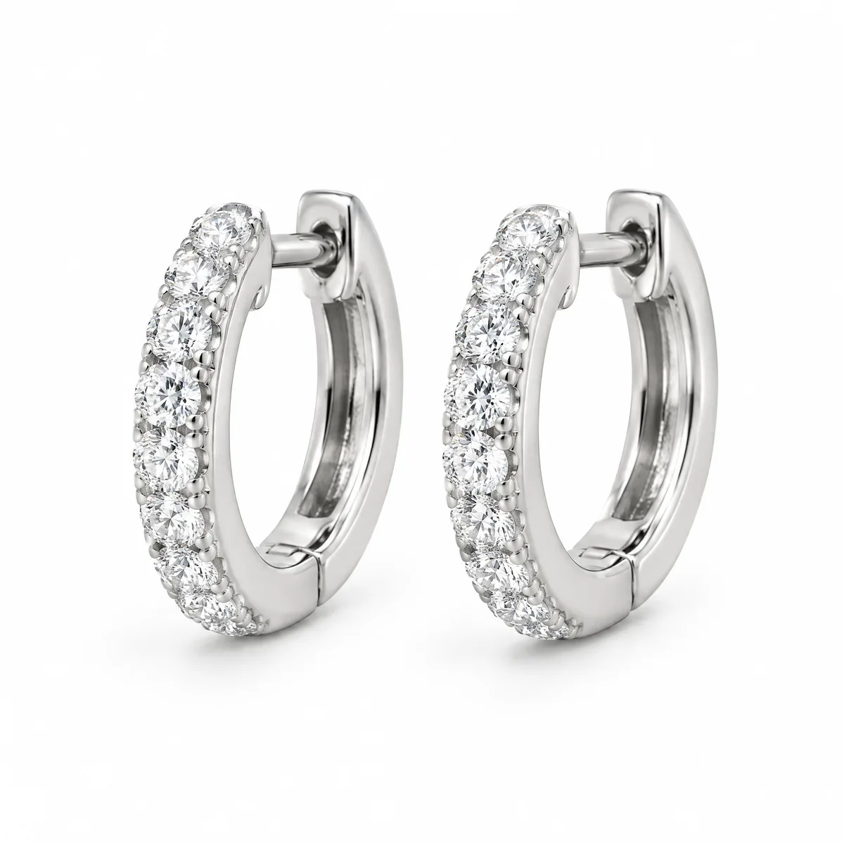 Pavé huggies: Small hoops in 18k white gold, set with pavé round diamonds