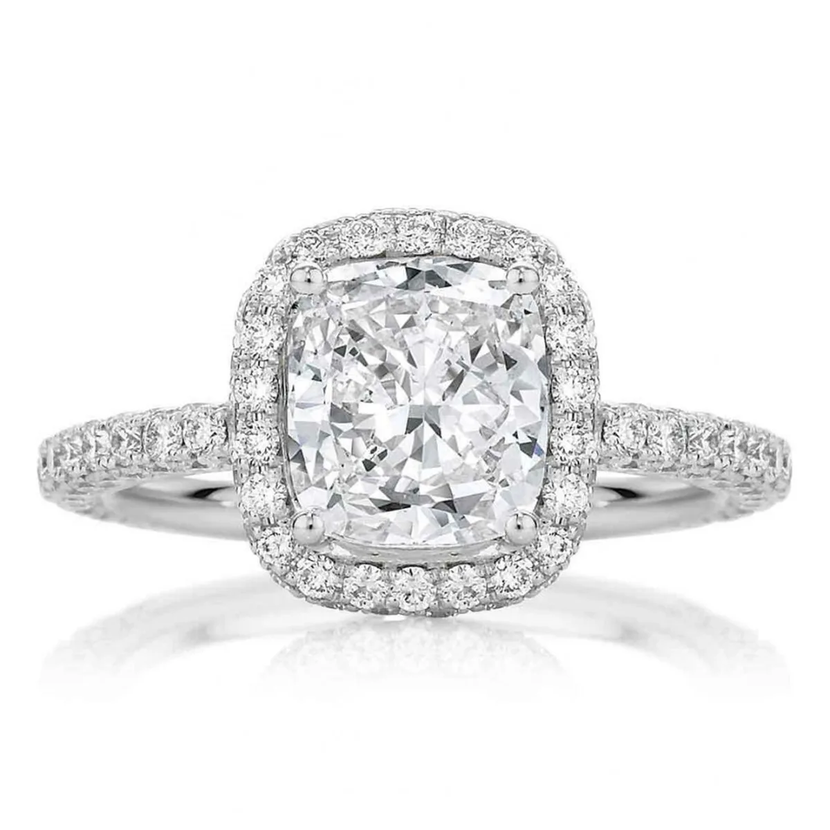 Indulge: Cushion-cut diamond engagement ring in a halo setting, embraced by a full eternity band